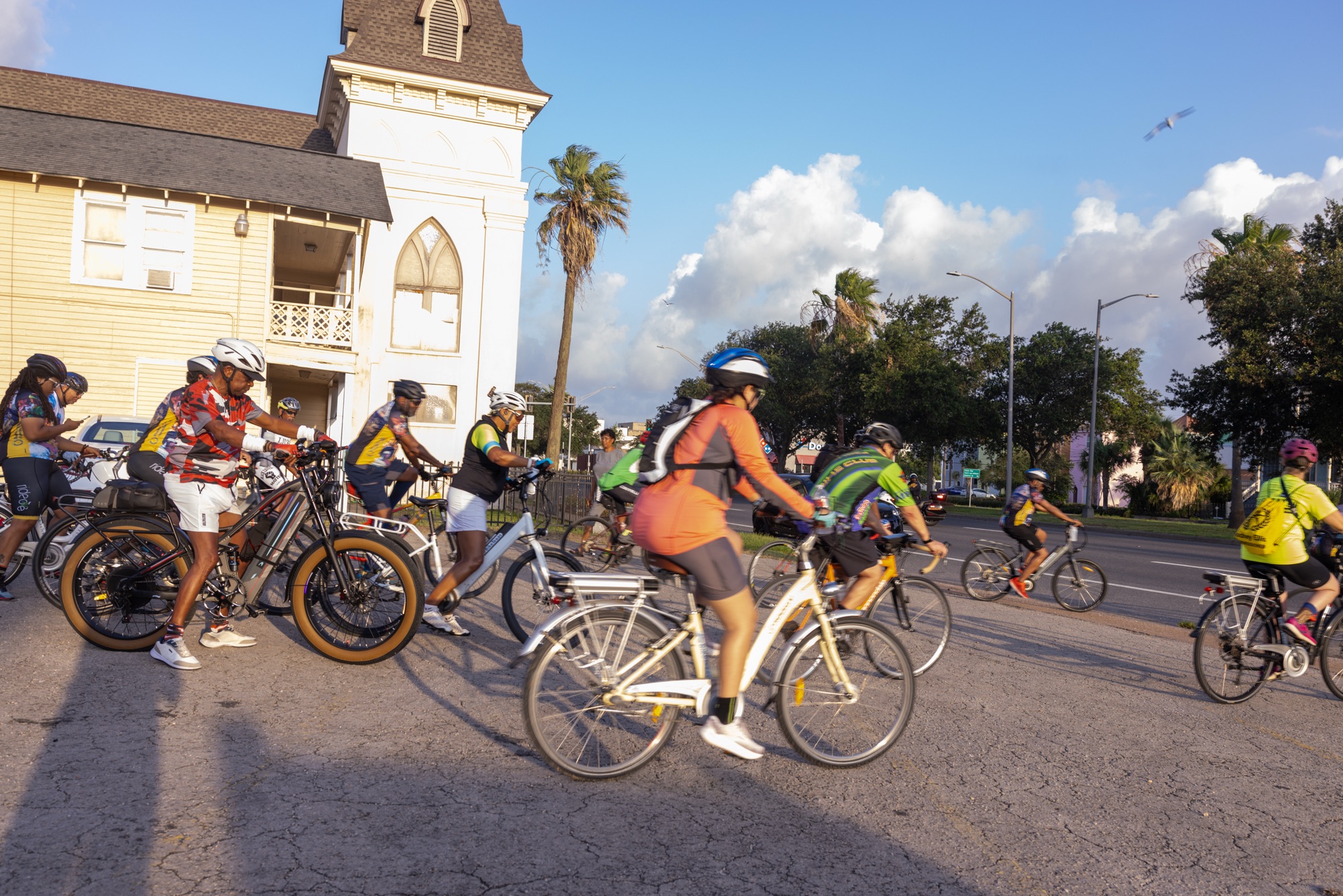 Group of cyclists riding past a historic church during the Emancipation Trail Bike Ride